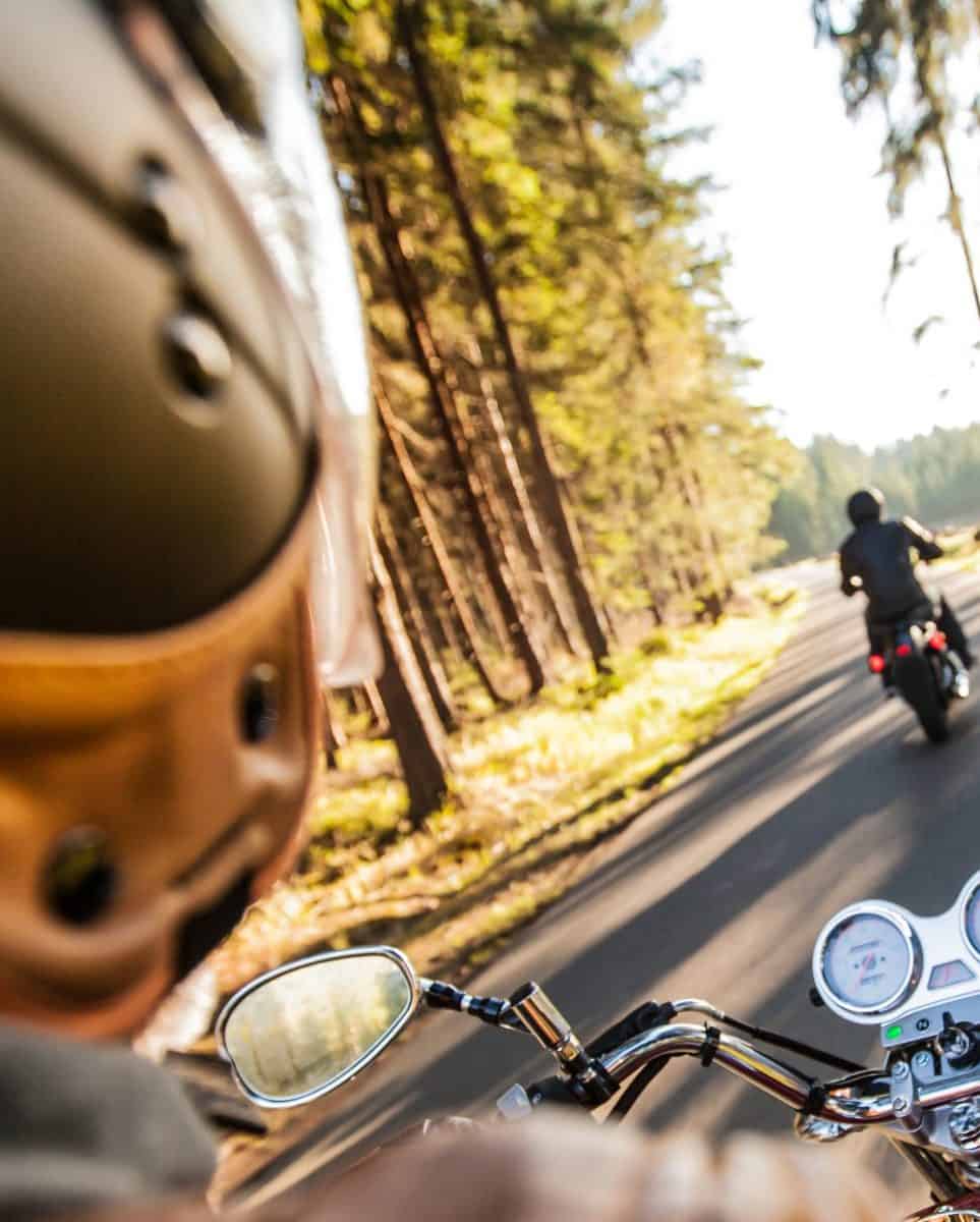 Man seat on the motorcycle on the forest road.